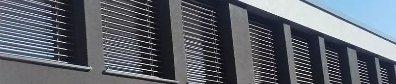 Zunanje žaluzije Senica na temni fasadi hiše z nizom oken